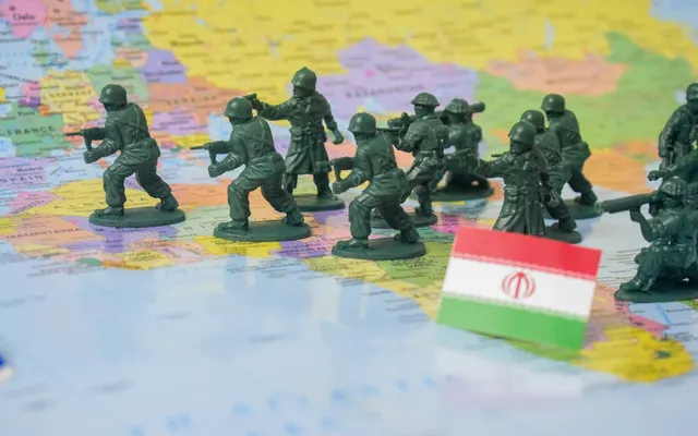 Miniature figures on a map with a flag of Iran depicting war